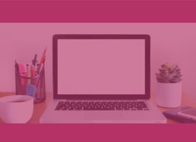 An open laptop on a desk with knickknacks